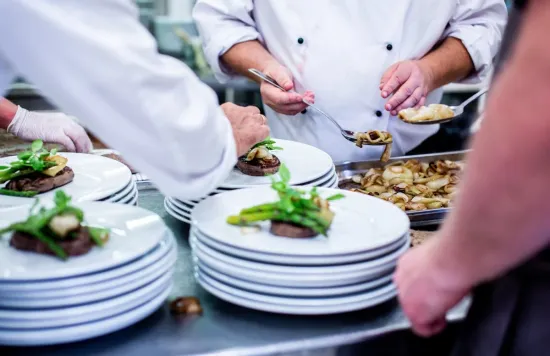 Kitchen staff preparing plates of food