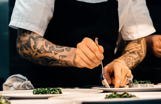 Kitchen worker assembling plated dish