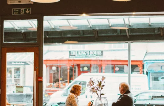 Two people sitting at table inside café