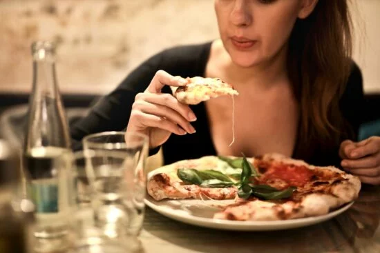 Woman eating pizza at table