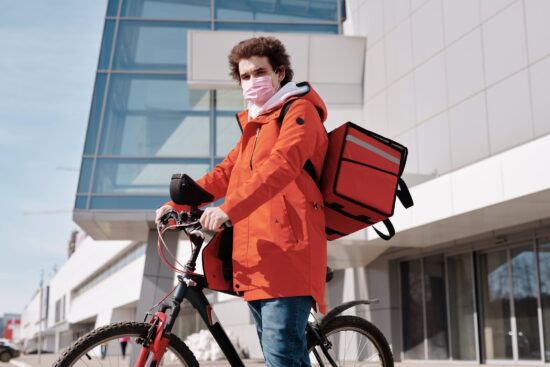 masked food delivery bicyclist